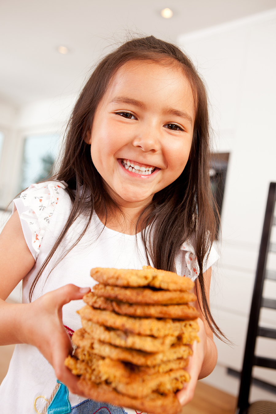Happy, laughing and smiling young cute girl holding stack of lar
